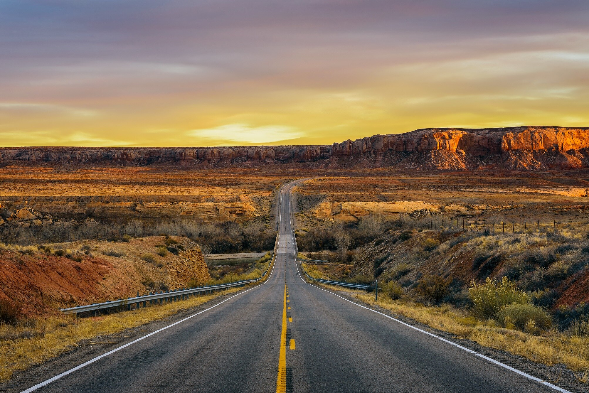 Shutterstock 1171486480 Sunset Over An Empty Road In Utah Near Its Border With Arizona USA