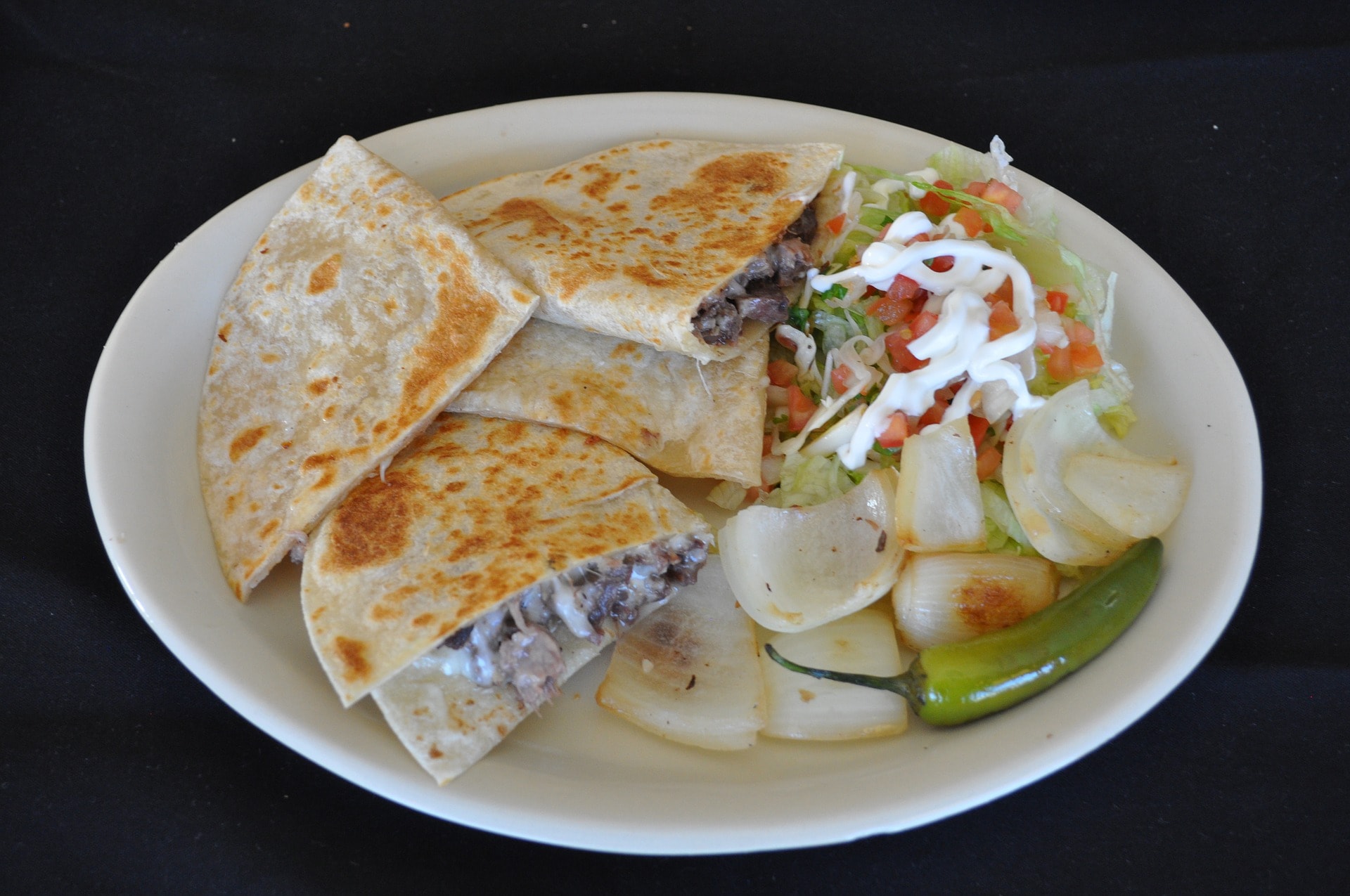 It’s a simple Mexican snack consisting of a flour or corn tortilla filled with cheese that melts well. It is commonly folded in half and consumed. Talking of its origins, it is known that the cheese was brought to Mexico by the Spaniards along with other dairy products in colonial times, and the thin flatbreads were already a staple of the Mesoamerican people. Its name in Spanish literally means, ‘little cheesy thing’. 